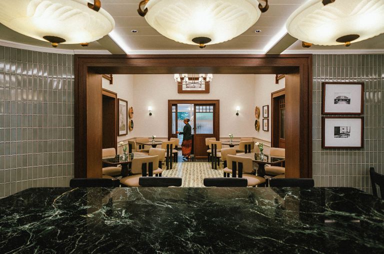 Pekerja di Uma Oma Heritage sedang membuka pintu masuk untuk para tamu